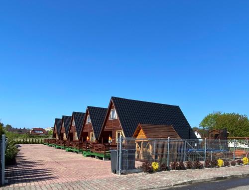 a row of wooden houses with black roof at Komfortowe Domki Dar in Sianozety