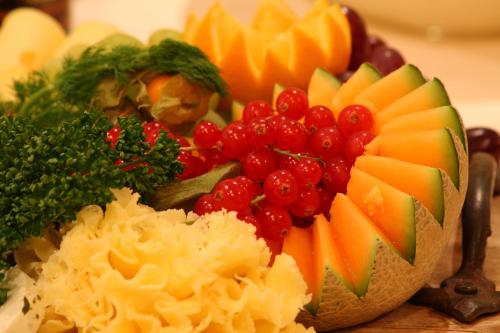 a bowl of fruit and vegetables on a table at Hotel Acht Linden in Egestorf
