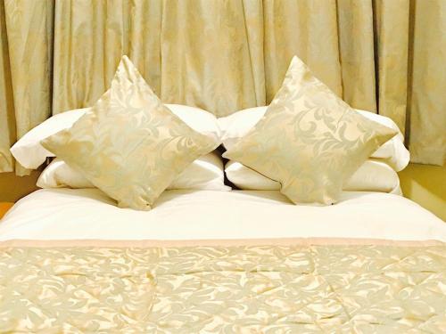 a bed with four pillows on top of it at Grainger House Hotel in Newcastle upon Tyne