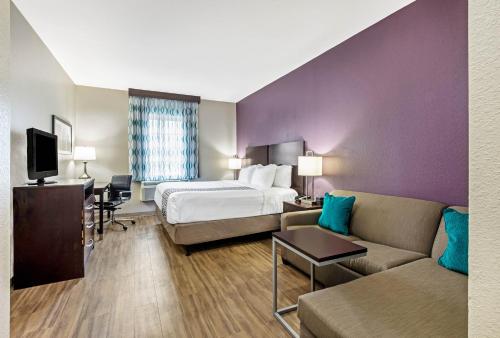 a hotel room with a bed and a couch at La Quinta by Wyndham New Cumberland - Harrisburg in New Cumberland