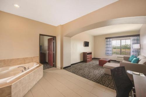 a large bathroom with a tub and a living room at La Quinta by Wyndham Oklahoma City -Yukon in Yukon