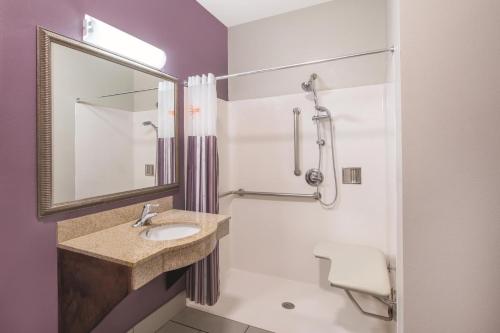 a bathroom with a sink and a mirror and a toilet at La Quinta by Wyndham Oklahoma City -Yukon in Yukon