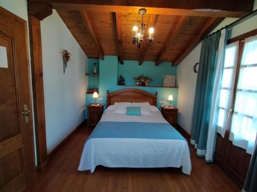 um quarto com uma cama grande num quarto com paredes azuis em Aldalurberea em Etxalar