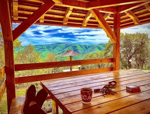 a table in a cabin with a view of a mountain at Etno selo Milanovic - Nonac in Kuršumlija