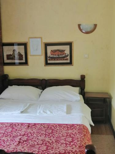 a bedroom with a bed and two pictures on the wall at Villa Bozovic in Zlatibor