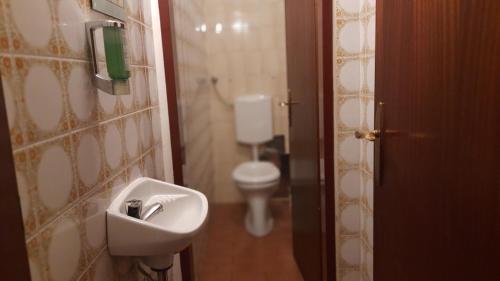 ein Badezimmer mit einem weißen WC und einem Waschbecken in der Unterkunft Pension Lerner in Wien
