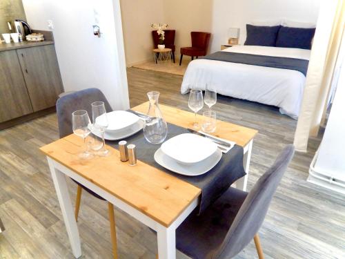 a dining room with a table and chairs and a bed at L'appart Moulin des Thermes Metz in Metz