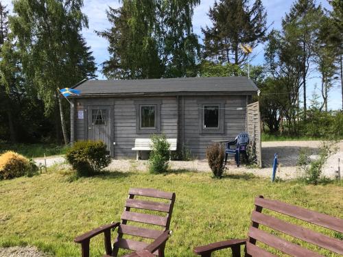 a small cabin with two benches in front of it at FAXESTUGORNA in Abbekås