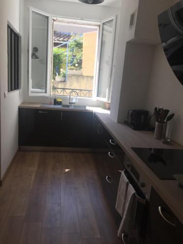 une cuisine avec un évier et une fenêtre dans l'établissement Gîte Lou Mounié provençal, à Nyons