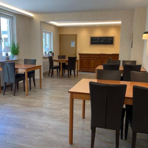 an empty waiting room with tables and chairs at Hotel Wintersmühle in Bielefeld