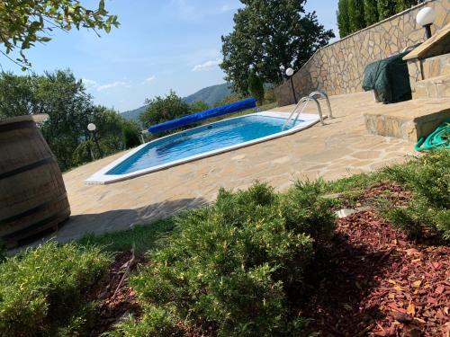 a swimming pool in a yard next to a wall at Etno selo Milanovic - Nonac in Kuršumlija
