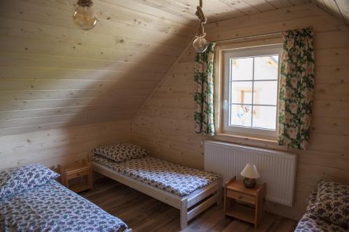 1 Schlafzimmer mit 2 Betten und einem Fenster in der Unterkunft Domki - Zajazd Zieleńska Polana in Wisła