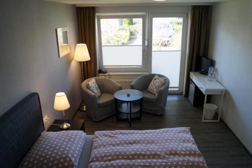 a hotel room with a bed and a couch and chairs at Hotel Villa Undine in Grömitz