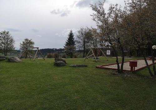 a park with an empty playground with rocks in the grass at Apartment Michaela in Sankt Englmar