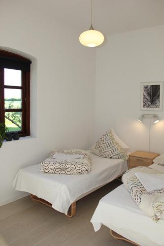 two beds in a room with a window at Munkebjerg Bed & Breakfast in Børkop