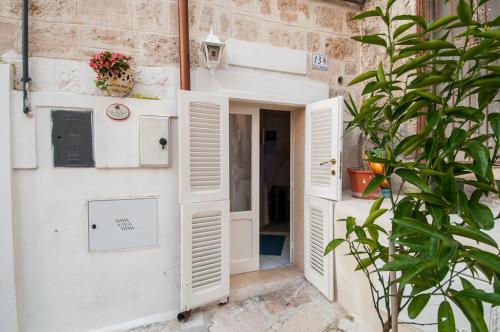 a building with white doors and a plant at Anna's Rose Holiday Home in Monopoli