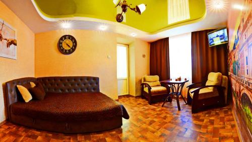 a bedroom with a bed and a living room at ApartLux Chernigov in Chernihiv