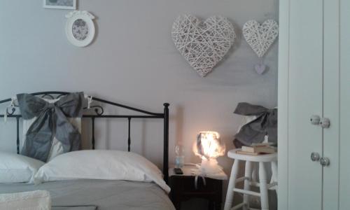 a bedroom with a bed and hearts on the wall at Anna's Rose Holiday Home in Monopoli
