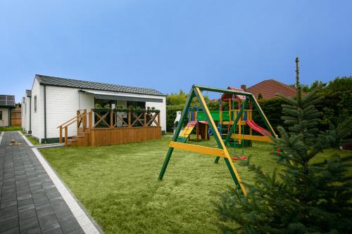 un parco giochi in un cortile con una casa di Domki z klimatem a Ustka