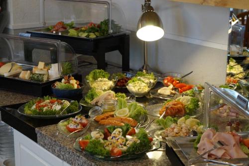 a buffet with many plates of food on a counter at Hotel Villa Undine in Grömitz