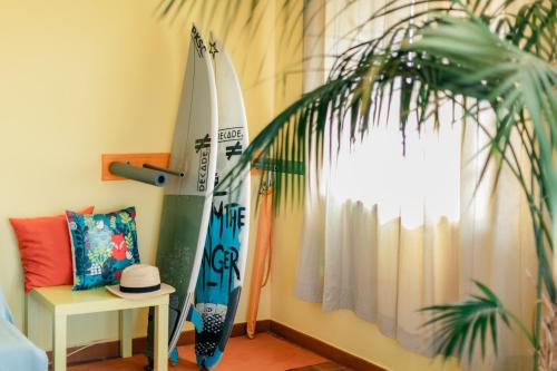 una stanza con due tavole da surf, un tavolo e una pianta di Peniche Beach House a Peniche