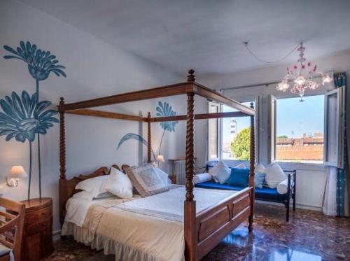 a bedroom with a canopy bed and a large window at Casa Sulla Laguna in Murano