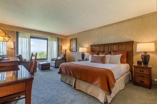 een hotelkamer met een groot bed en een bureau bij The Omni Grove Park Inn - Asheville in Asheville