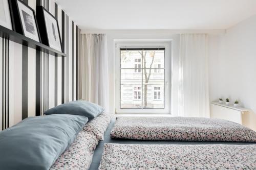 a white bedroom with a bed and a window at Your Cozy Home * 12 min to City Center in Vienna
