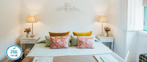 a bedroom with a bed with pillows and two lamps at Dona Fina Guest House in Mirandela
