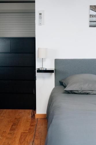 a bedroom with a bed and a lamp on a night stand at Les rives de Sax in Dinant