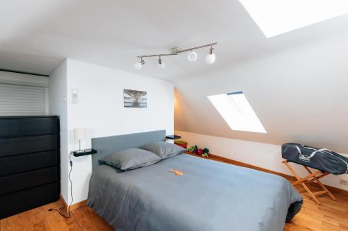 a bedroom with a blue bed and a skylight at Les rives de Sax in Dinant