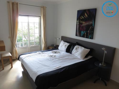 1 dormitorio con 1 cama grande y ventana en Encantador T1 praia Senhora da Rocha - Algarve en Porches