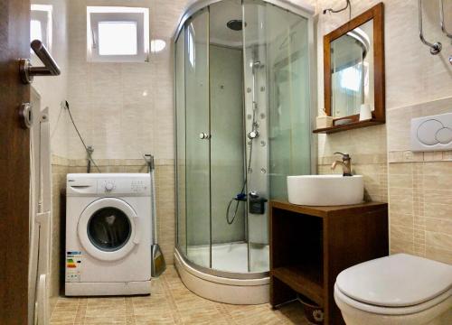 a bathroom with a shower and a washing machine at Apartments Violeta in Budva