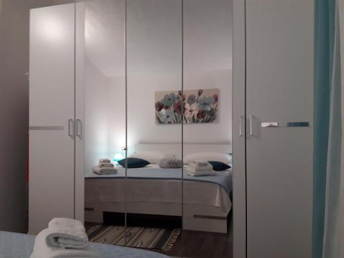 a bedroom with a bed and a mirrored cabinet at Ana Marija in Solin