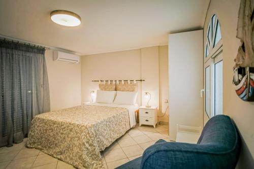 - une chambre avec un lit et une chaise bleue dans l'établissement San Marco Luxury Apartment Zante, à Zante