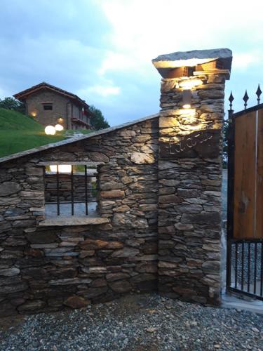 a stone wall with a gate and a fence at LA DRIT in Paesana