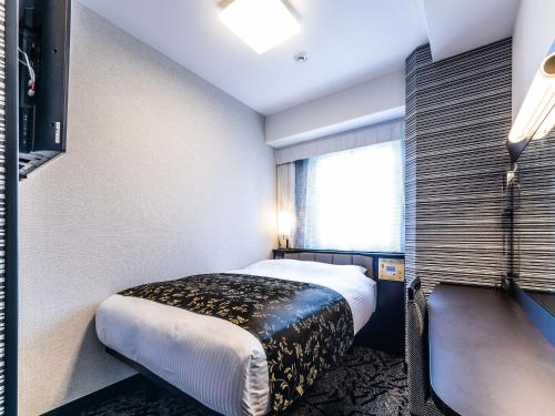 a hotel room with a bed and a window at APA Hotel Nambaminami Ebisucho Eki Shinsekai in Osaka