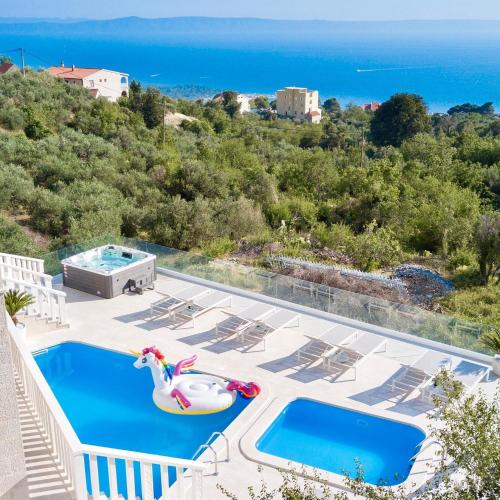 uma piscina com um brinquedo insuflável e o oceano em Villa Hills em Makarska