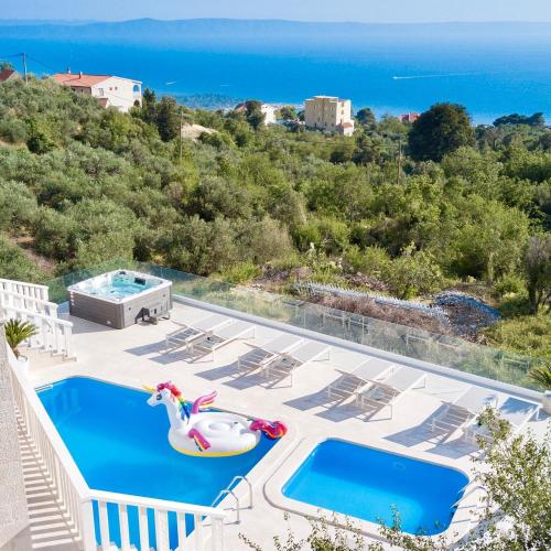 una piscina con giocattolo gonfiabile e l'oceano di Villa Hills a Makarska