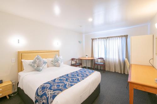 a hotel room with a large bed and a table at Auckland Newmarket Motel in Auckland