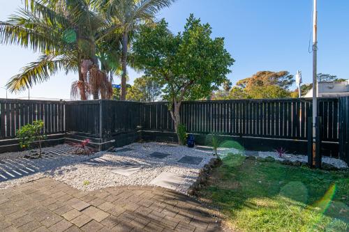 a backyard with a fence and a palm tree at Auckland Newmarket Motel in Auckland