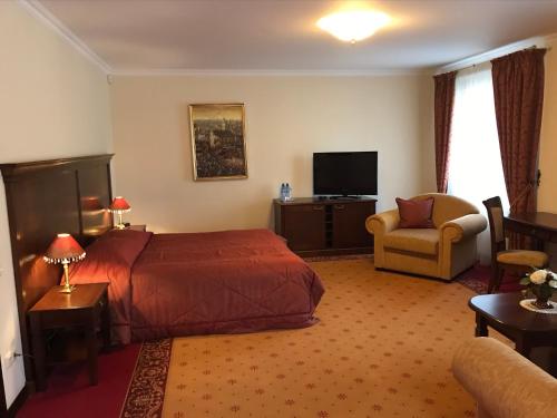 a hotel room with a bed and a chair and a television at Guest House Pirklių Namai in Klaipėda