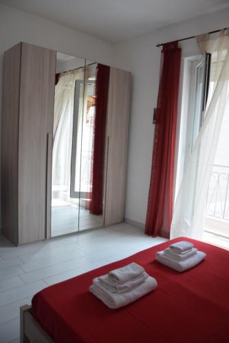 um quarto com uma cama vermelha e um espelho em Casa di marco2 em Canosa di Puglia