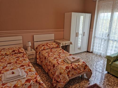 a bedroom with two beds and a window at CASA CELESTE in Ponte San Pietro