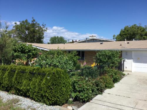 une maison avec un garage et quelques buissons dans l'établissement Your home away from home, à Kelowna