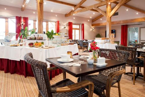 ein Esszimmer mit Tischen und Stühlen mit weißen Tischdecken in der Unterkunft Relais des Vigiers in Monestier