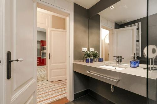 a bathroom with a sink and a mirror at Bcn Paseo De Gracia Rocamora Apartment in Barcelona