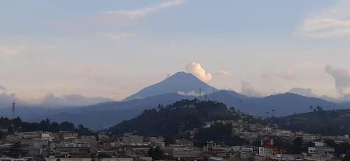una montaña en la distancia con una ciudad y edificios en Crysol Center Hotel, en Chimaltenango