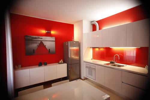 a kitchen with red walls and a stainless steel refrigerator at Apartment Villa Mandria in Opatija