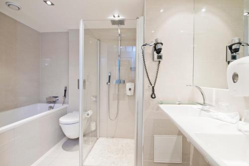a bathroom with a shower and a toilet and a sink at Thon Hotel Oslofjord in Sandvika